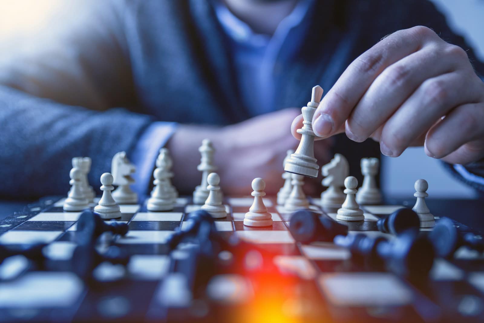 Une partie d’échecs en cours, la main du joueur sur une pièce
